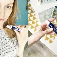 Kobieta pokazuje maść ichtiolową na pryszcze. Tubka z ciemnoniebieską etykietą.