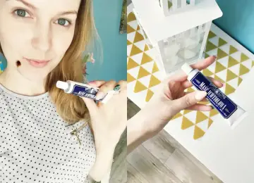 Kobieta pokazuje maść ichtiolową na pryszcze. Tubka z ciemnoniebieską etykietą.